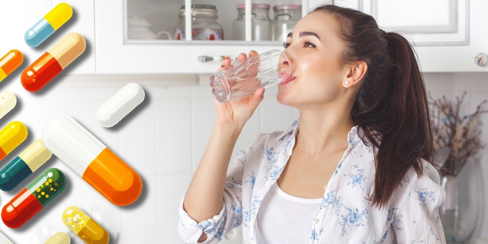 Woman drinking a glass of water with floating prescription pills, illustrating pharmaceuticals in drinking water and water quality research.