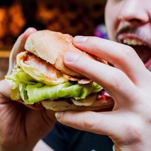 Close-up of a sandwich with fresh lettuce, representing the raw produce often linked to Cyclospora outbreaks.